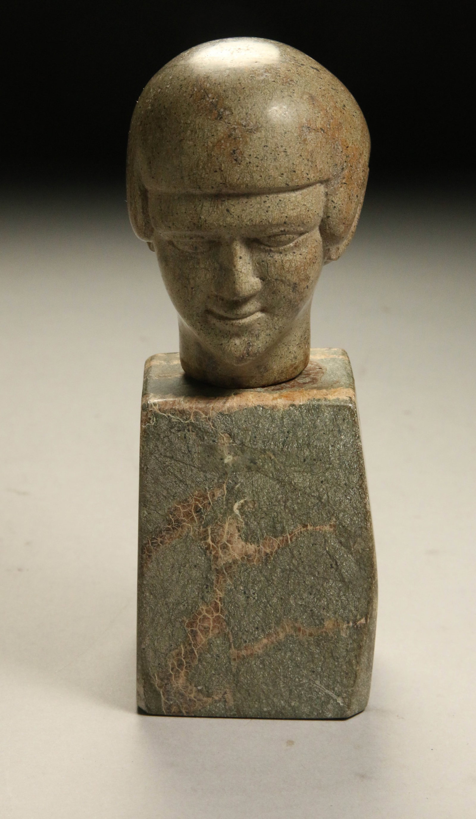 Green Stone Carved Head: A green stone carved head on a green stone base.
