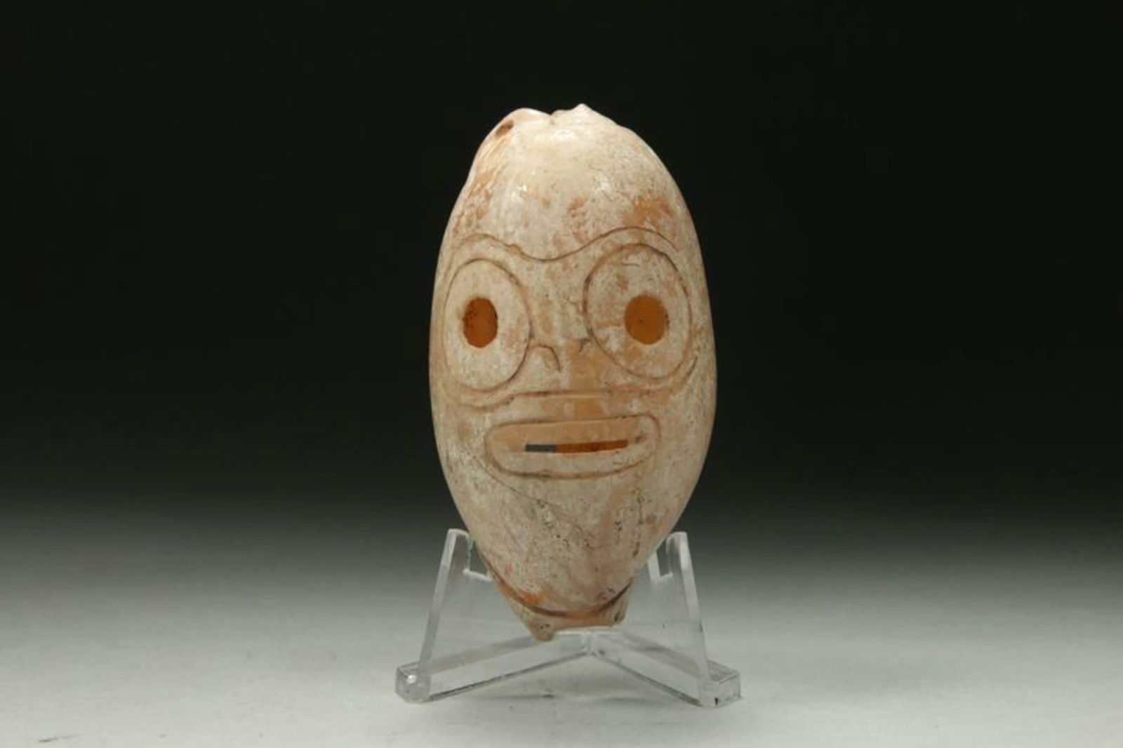 Pre-Columbian Taino Carved Shell: A Taino carved shell with anthropomorphic face. Suspension holes. 2-3/4" L Provenance: Ex collection New York, NY