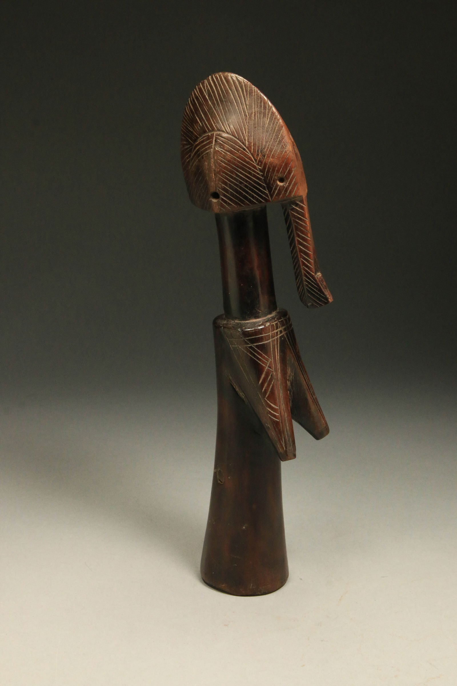 African Art - Mossi Doll - Burkina Faso: Traditional figure made from one piece of wood standing on a broader base. 12" H. Provenance: Ex. Collection Thomas Wheelock. The doll displays the characteristics of an adult woman, with suggestions