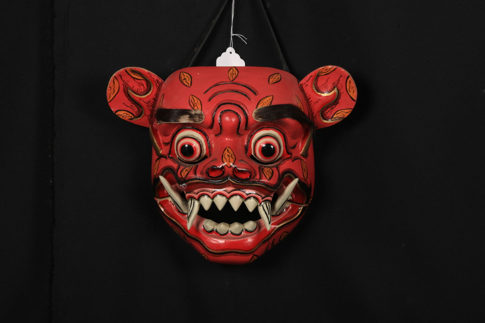 Japanese Oni Mask: A Japanese demon mask, red with black highlights, horse hair eyebrows above bulging eyes, fanged articulated mouth. 10" W x 8" H.