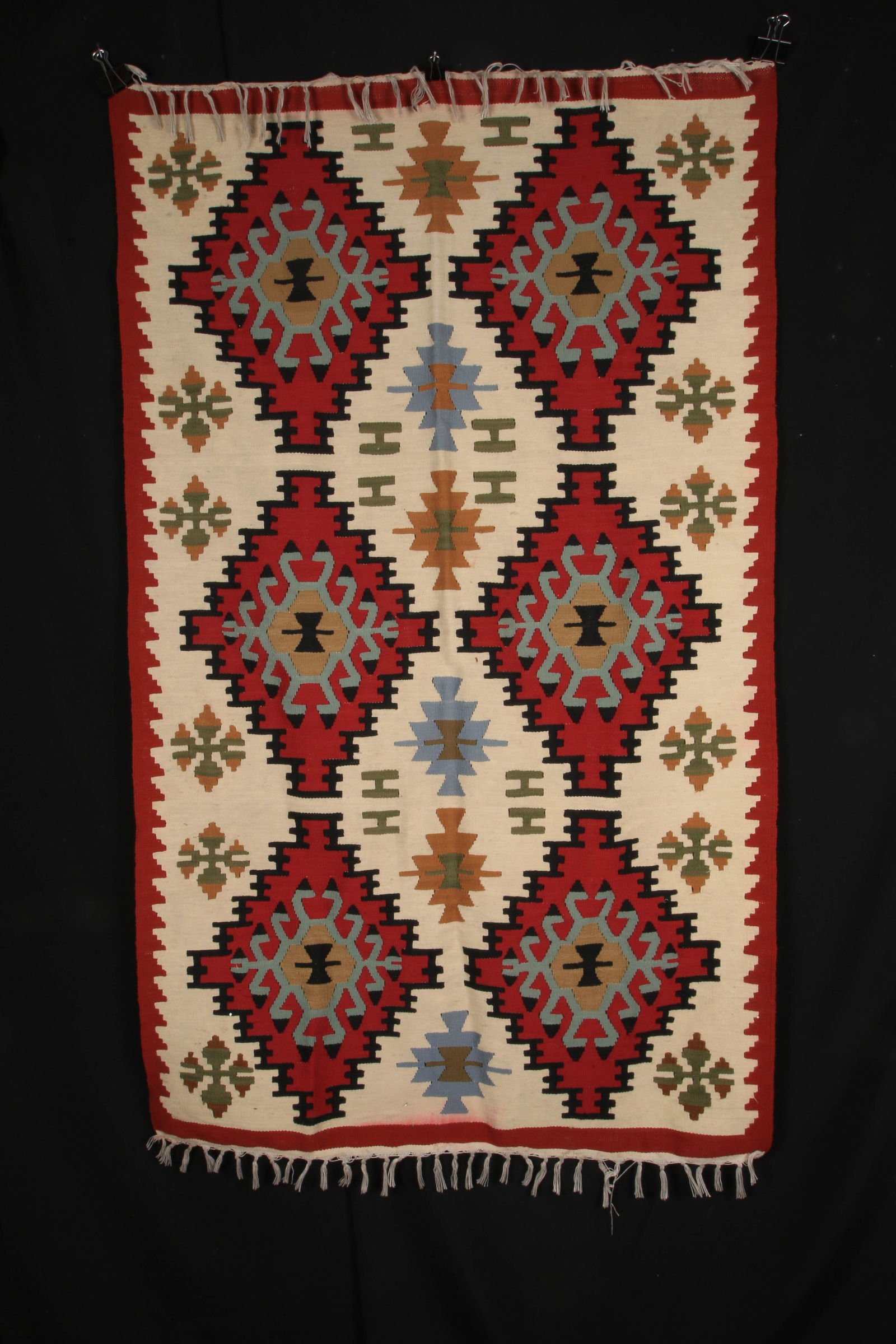Handwoven Kilim Rug - Turkey: A handwoven Kilim featuring prominent diamond shapes which often symbolize protection or the four elements. The smaller, stylized motifs within the diamonds and borders can represent various