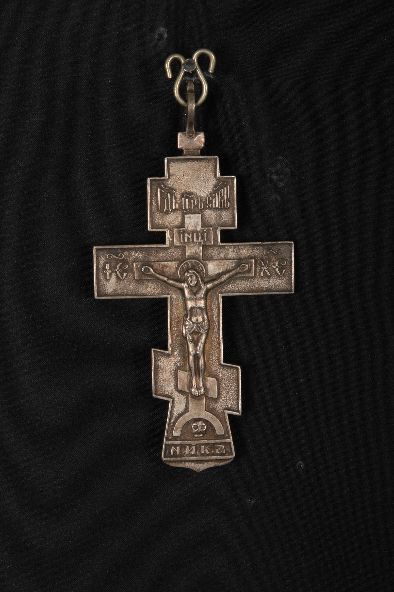 Russian 19th Century Orthodox Silver Cross: A large Pectoral cross. This silver cross depicts the cruxification of Jesus Christ with a halo behind his head, feet are side by side indicating it is in Byzantine style. The Cyrillic letters of I.H.