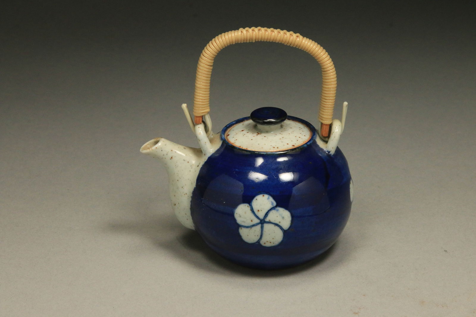 Japanese Dobin Teapot: A miniature Kyusu style arita-yaki porcelain teapot with wicker handle. Signed on reverse of the lid.