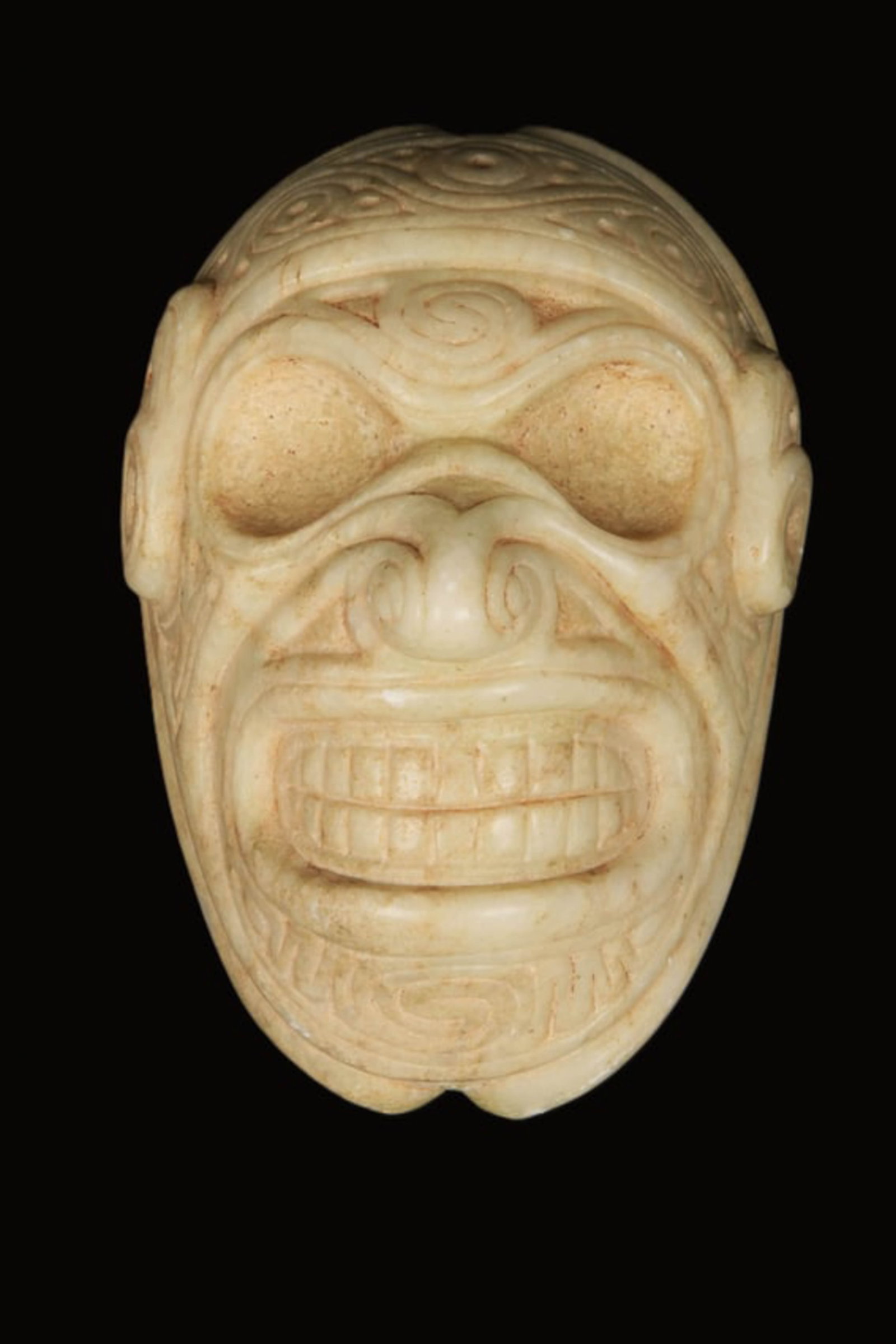 Pre-Columbian Taino Zemi Mask-Mortar: A white stone Zemi with a broad mouth, hollow eyes, reverse is a concave mortar with two claws. 6" L. Provenance: Ex collection Tony Milton, NM.