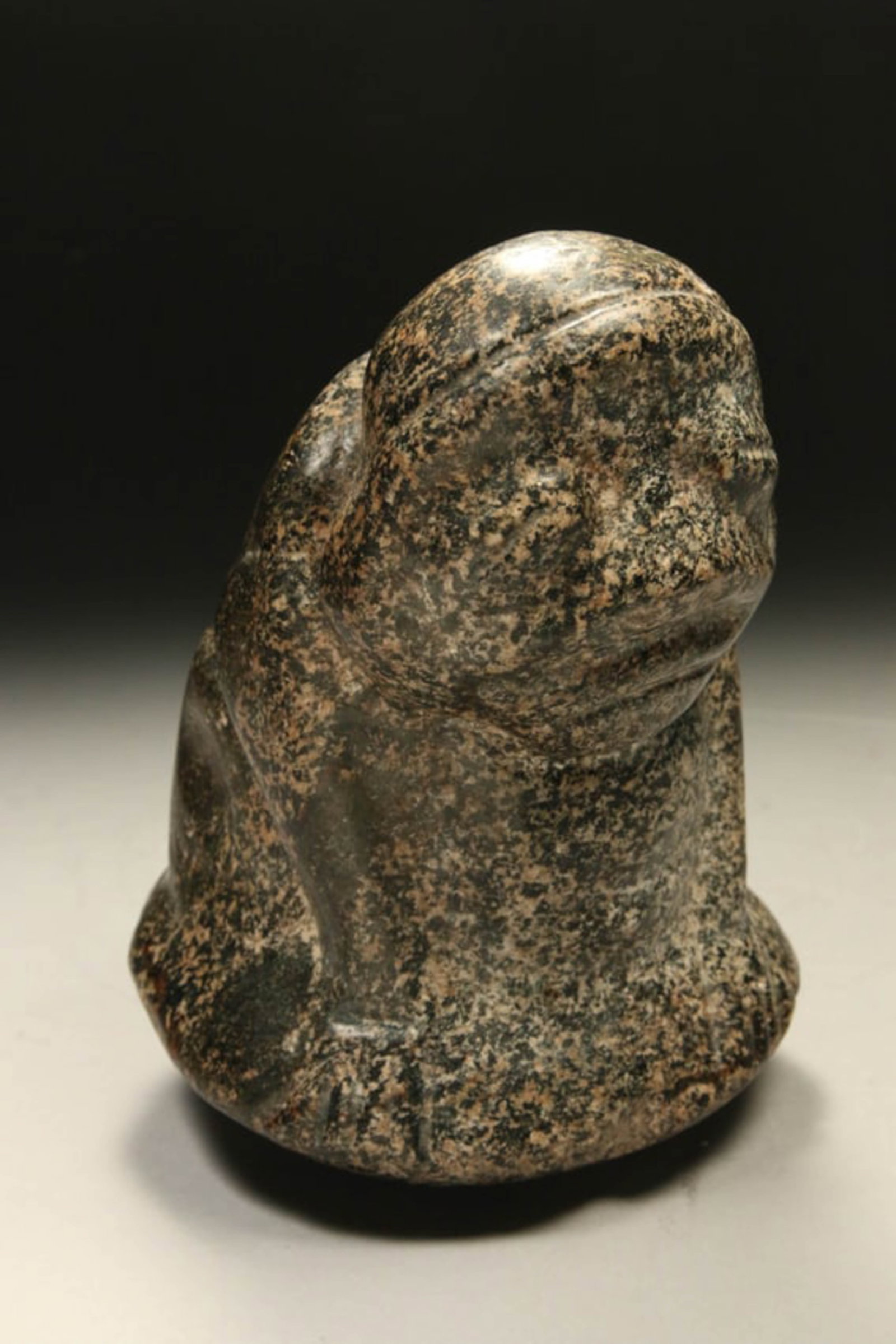 Pre-Columbian Pestle Statue: A large Taino pestle statue, a green speckled stone of a Zemi like figure with arms a sides, slightly bent over, standing on a round bottom which was used to grind substances. 7" H. Provenance: Ex