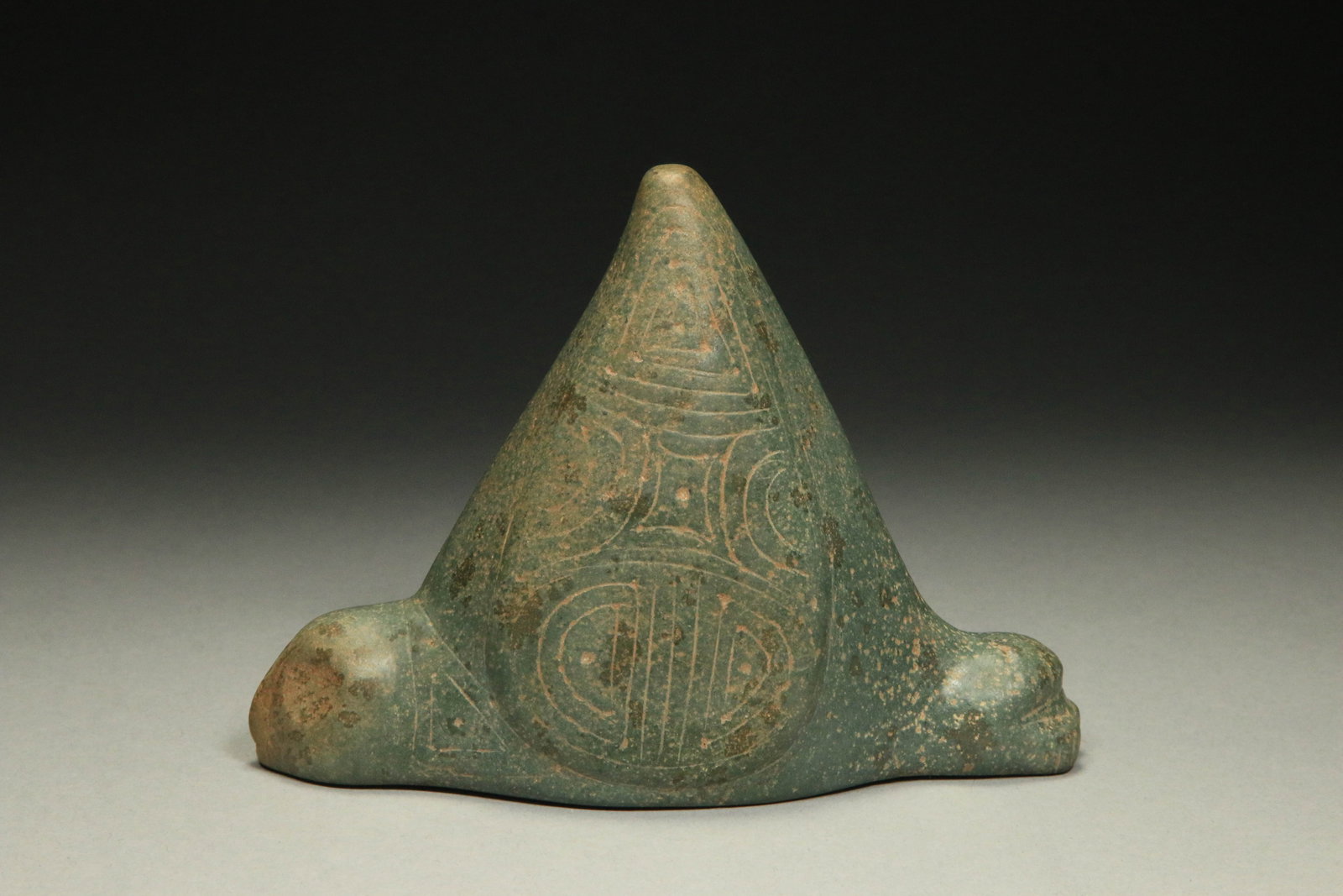 Pre-Columbian Taino Zemi: A speckled stone Zemi with head and legs, etched design on sides. 5-1/2" L. Provenance: Ex collection D. Paracas.