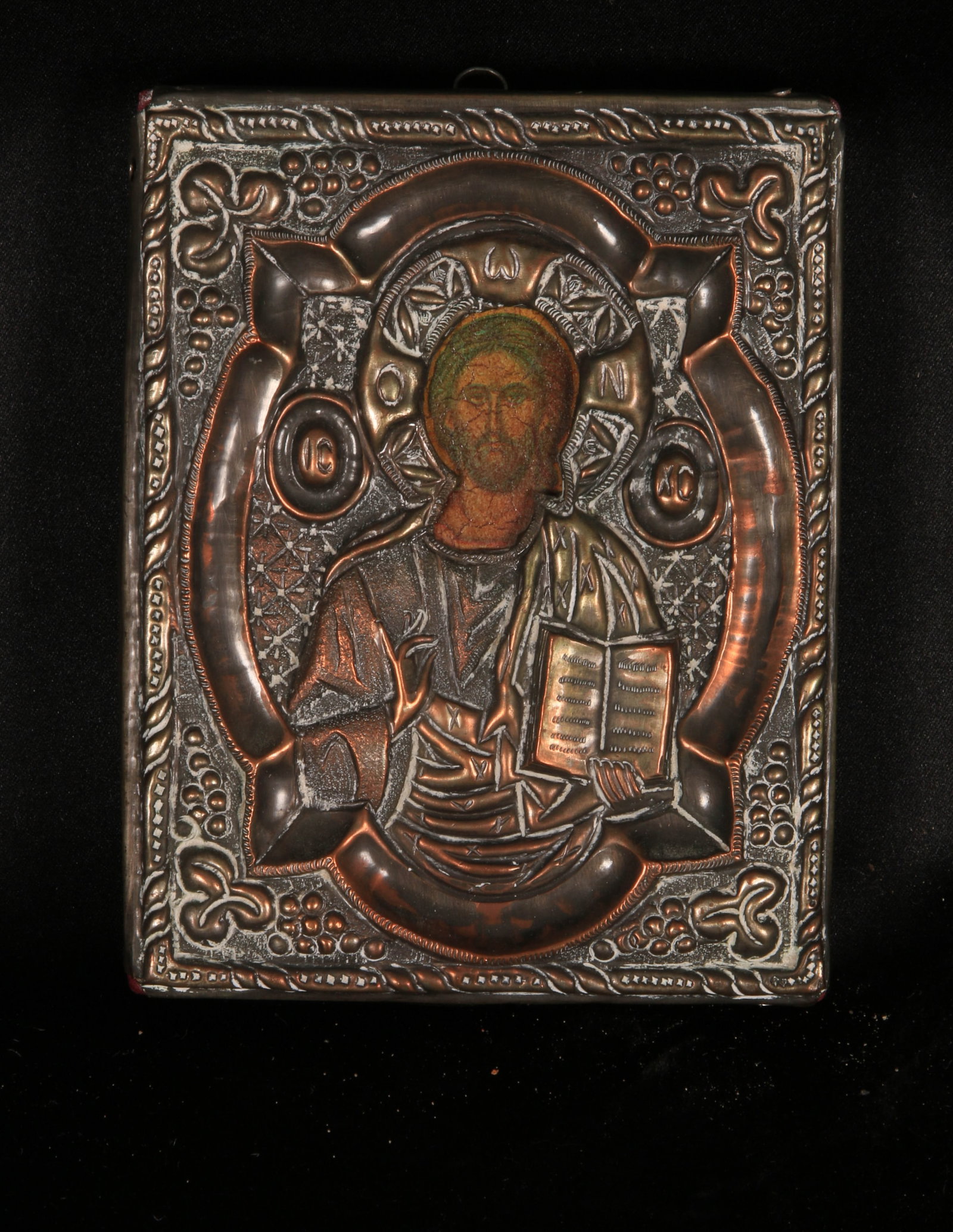 Russian Icon - Byzantine: A small Russian Icon with image of Christ Pantocrator holding the Gospels in left hand and making a gesture of blessing with the right hand. Hand painted with a copper and silver repousse riza over th