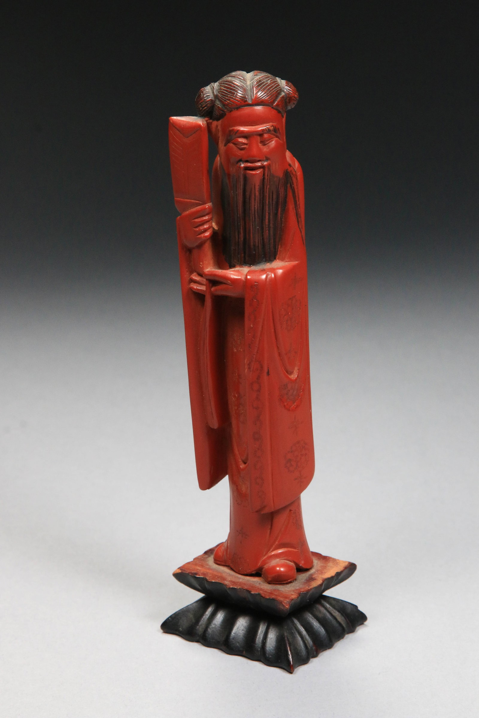 Chinese Red Lacquer Carving: A red lacquer wood carving of the immortal Shou Xing, God of Longevity. Mounted on a wood base. 6-1/2" H.