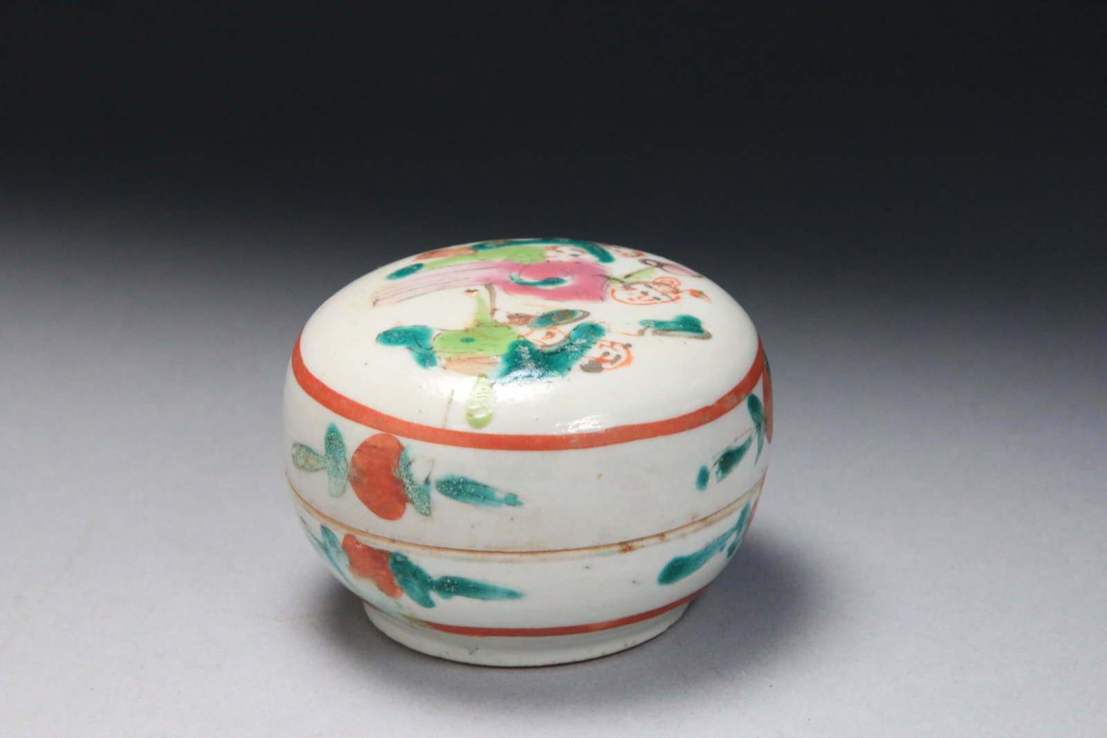 Chinese Porcelain Seal Paste Box: decorated in the famille-rose palette, characterized by soft pink and enamel colors. The design depicts a figural scene, frequently of children playing (a theme known as "100 boys" or "children playin