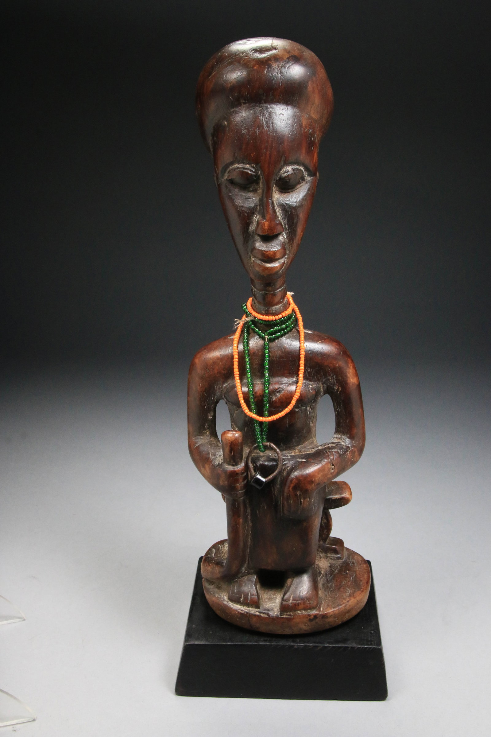 African Art Ashante Queen Mother Statue: A hand-carved wooden statue representing an Ashanti (Asante) Queen Mother from Ghana, West Africa. A high, elegant forehead, elongated neck, adorned with beads, seated on a ceremonial stool, holding a