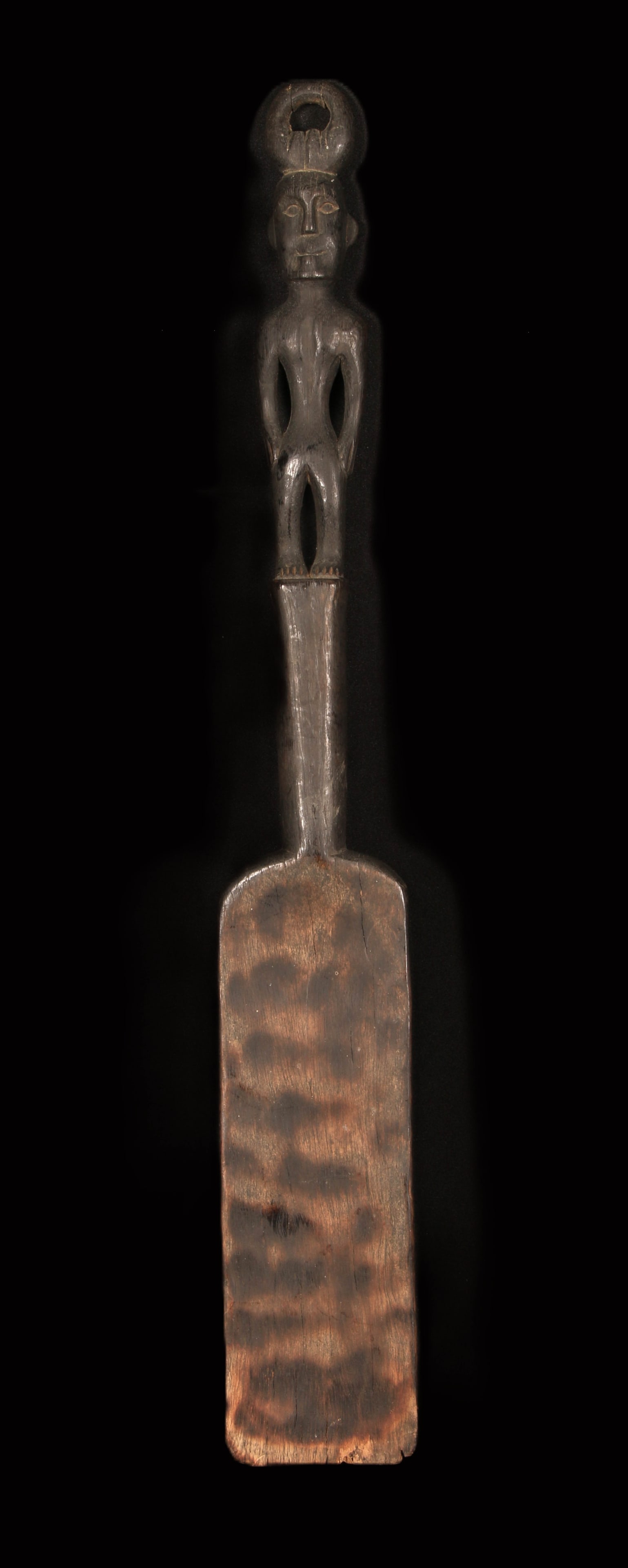 Philippine Cooking Spatula - Ifugao People: A large cooking spatula with a figurative ancestor form as handle, suspension loop at head. Large flat blade. 24" H.
