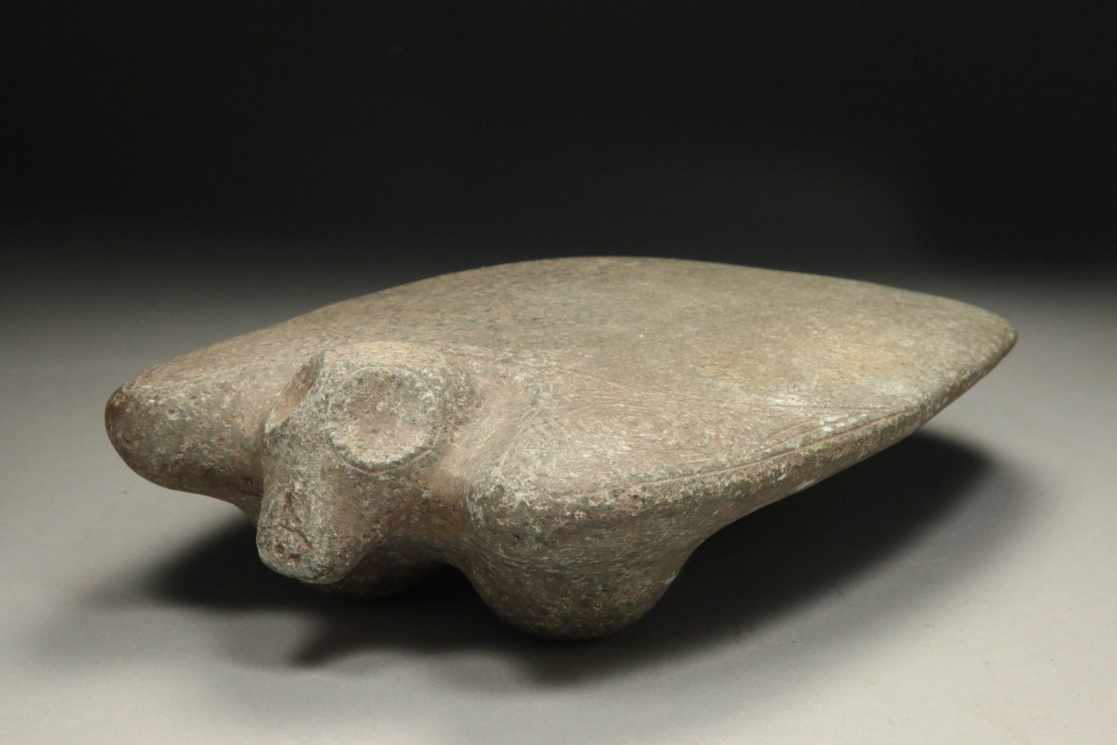 Pre-Columbian Metate: A Taino stone metate with a zoomorphic head, abstract design at shoulders, seating on three legs. 10" L. Provenance: Ex collection, New York, N.Y. Traditionally used as a practical tool for grinding c