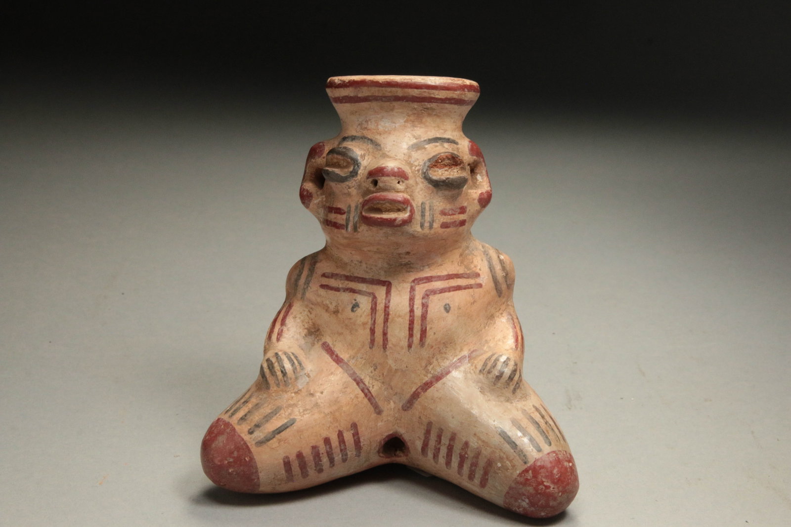 Pre-Columbian Nicoya Seated figure: Female effigy figure, Nicoya-Guanacaste region, Costa Rica. Seated figure with polychrome, coffee-bean eyes, ear spools and heavy facial and body striping. Most likely a fertility figure. 4-1/4" H.