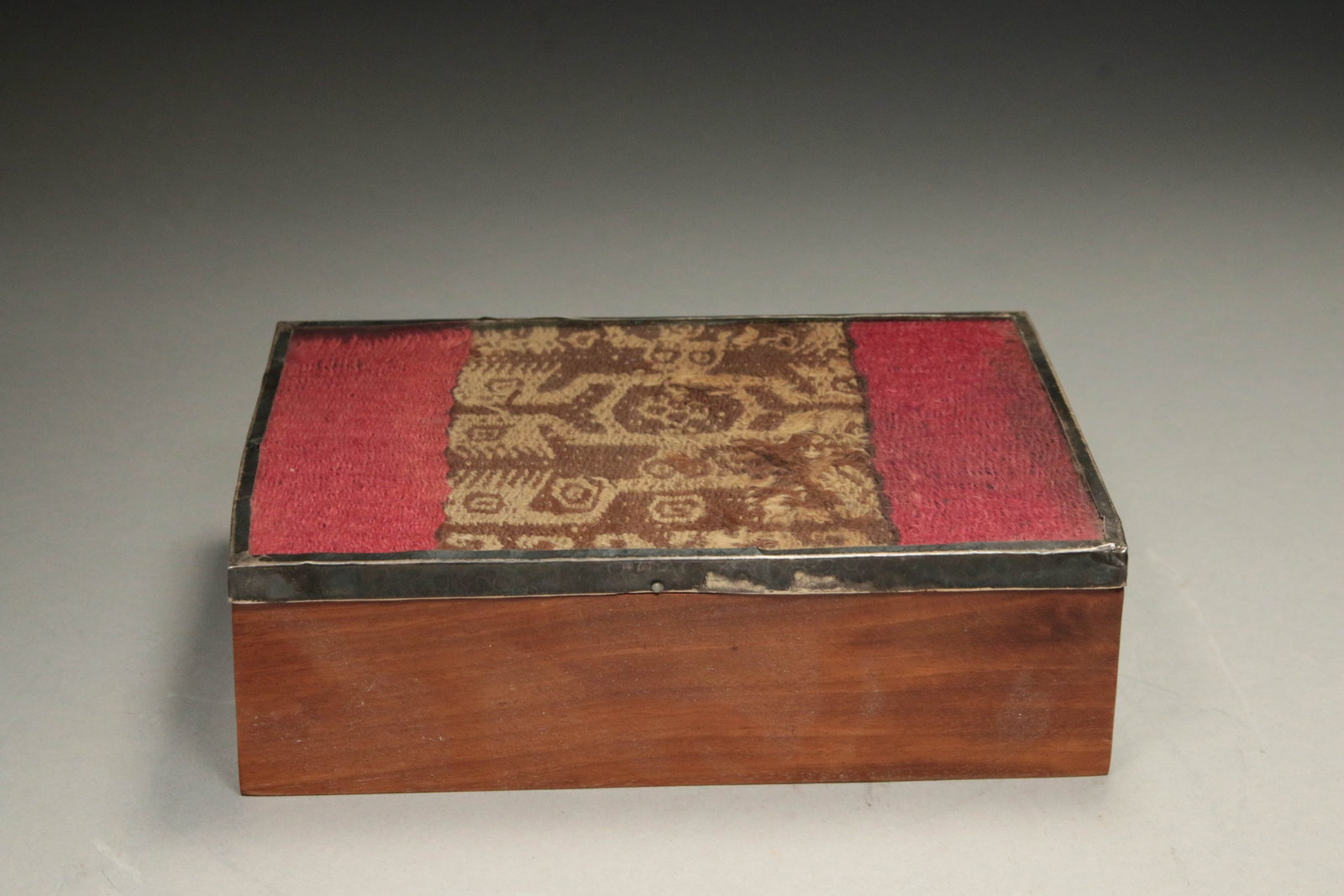 Pre-Columbian Textile w/Wood Box: A Peruvian rosewood box with silver trim, pre-Columbian textile on lid under glass. 7" x 5" x 2-1/4"