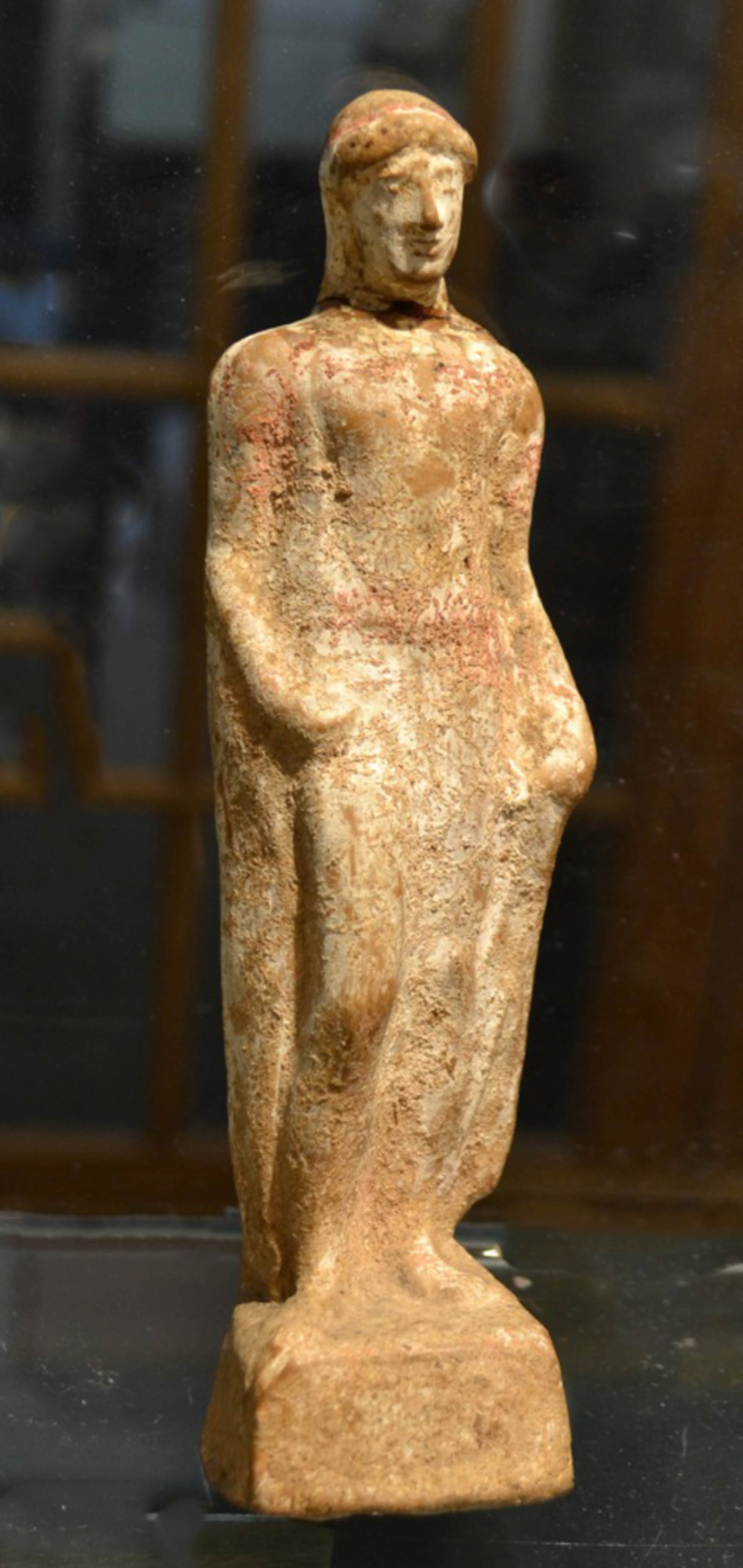 Ancient Greek Terracotta figure of a Man: Greek terracotta of a man wearing a head covering and a long flowing garment. His right leg bent at the knee. 4th - 5th Century B. C. 7.5" H. Provenance: New York City Collection,