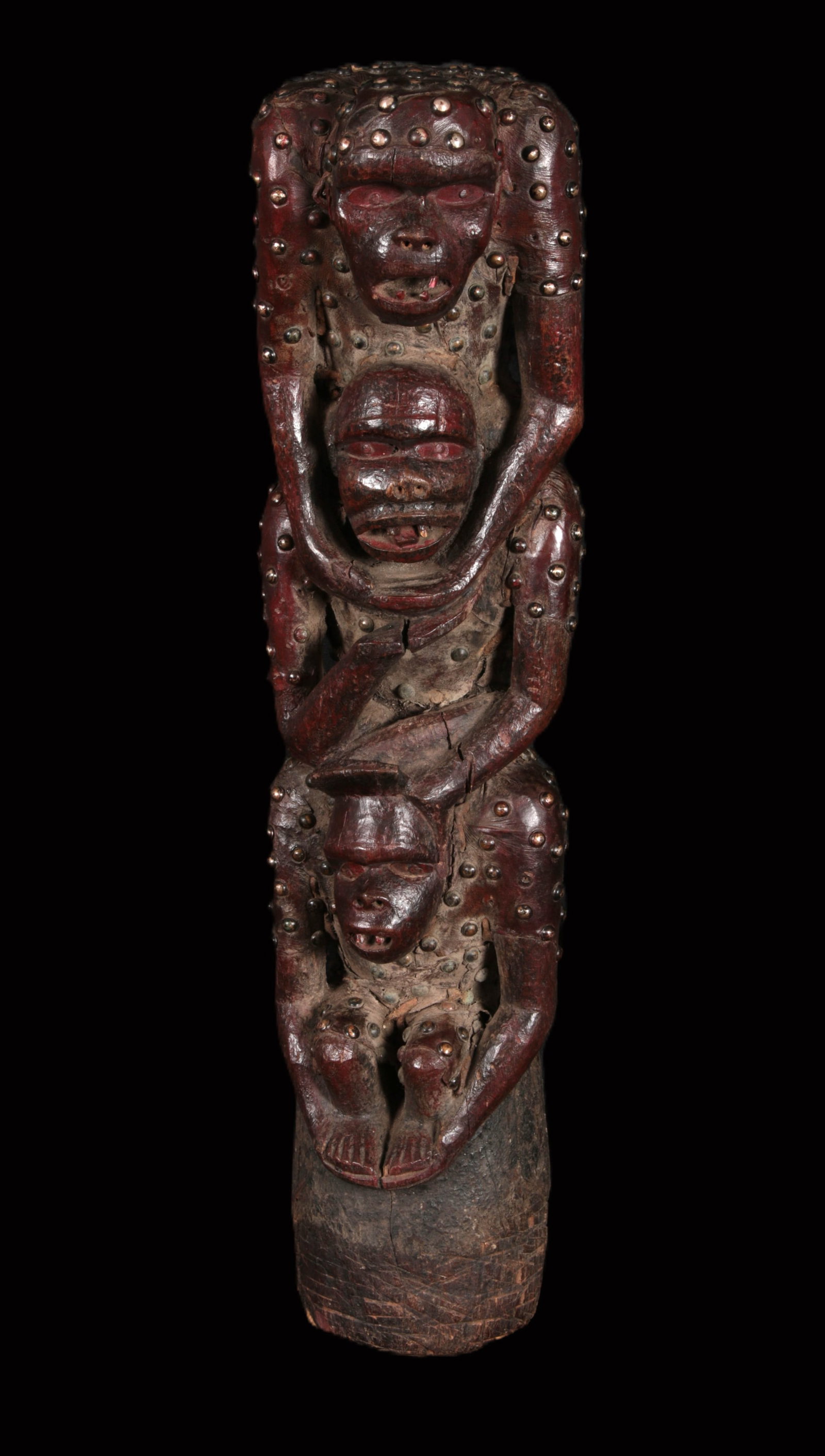 African Art Bulu Maternity Figure: A large wood maternity figure, Bulu people. Cameroon/Gabon. Three gorilla figures sitting on each other's shoulders, with metal nails embedded throughout. The figure has three cavities on reverse for 