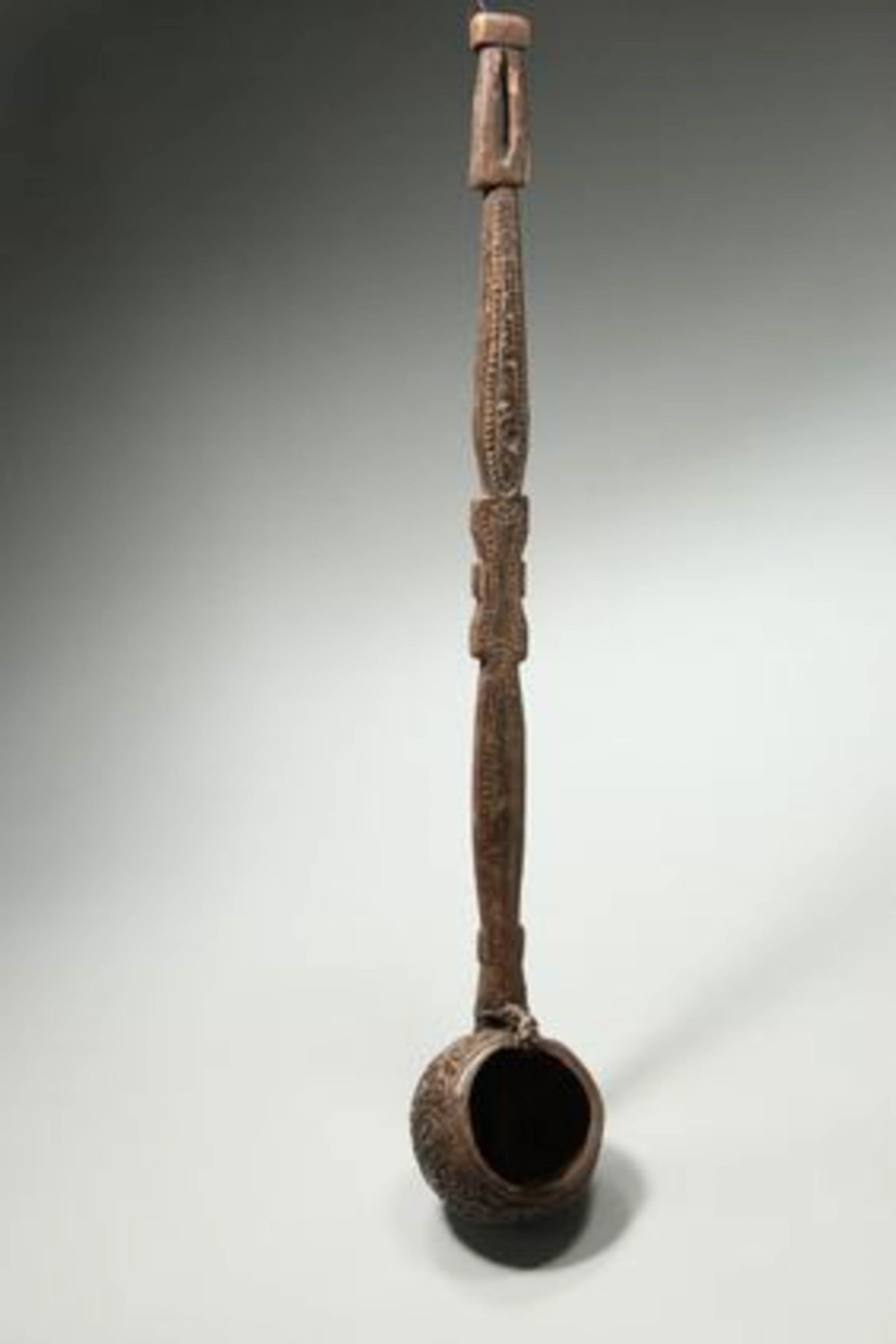 Papal New Guinea Ladle: A large carved coconut ladle, intricately carved handle and dipper, late 19th century - early 20th century. 22" L a rare carved tribal ladle originating from Papua New Guinea, specifically associated