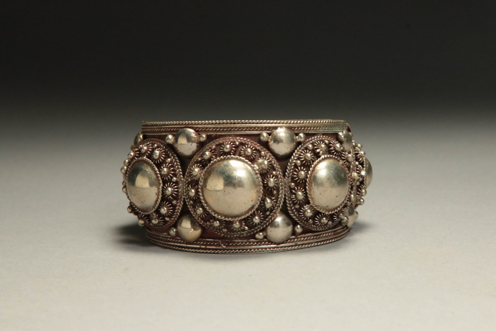 Siam Sterling Silver Cuff Bracelet: A handcrafted sterling silver bracelet, Thailand, with silver domes, cannetille and filigree embellishments, textured silver beaded borders. 3" dis.