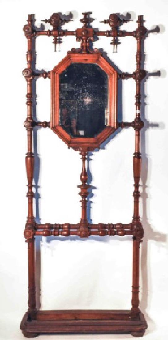 Intricately Carved Mahogany Victorian Hall Stand: This beautiful and unique Victorian mahogany hall stand sports a beveled mirror and features intricately hand carved ornamental detail for hanging coats and hats. The bottom of the stand features a tr