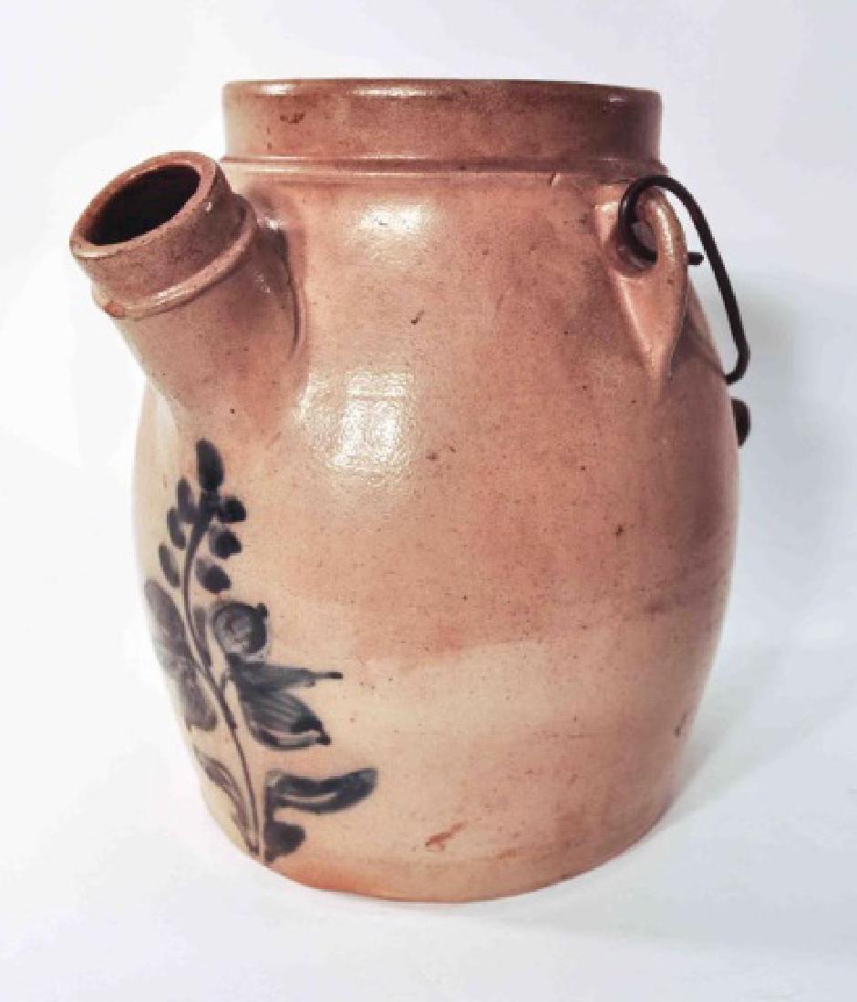 Antique Blue Decorated Stoneware Batter Jug: This Antique Blue Decorated Stoneware Batter Jug with bail handle. features a classic cobalt freehand decorated blue flower. Batter jugs were extremely utilitarian in nature and were used on a nearly