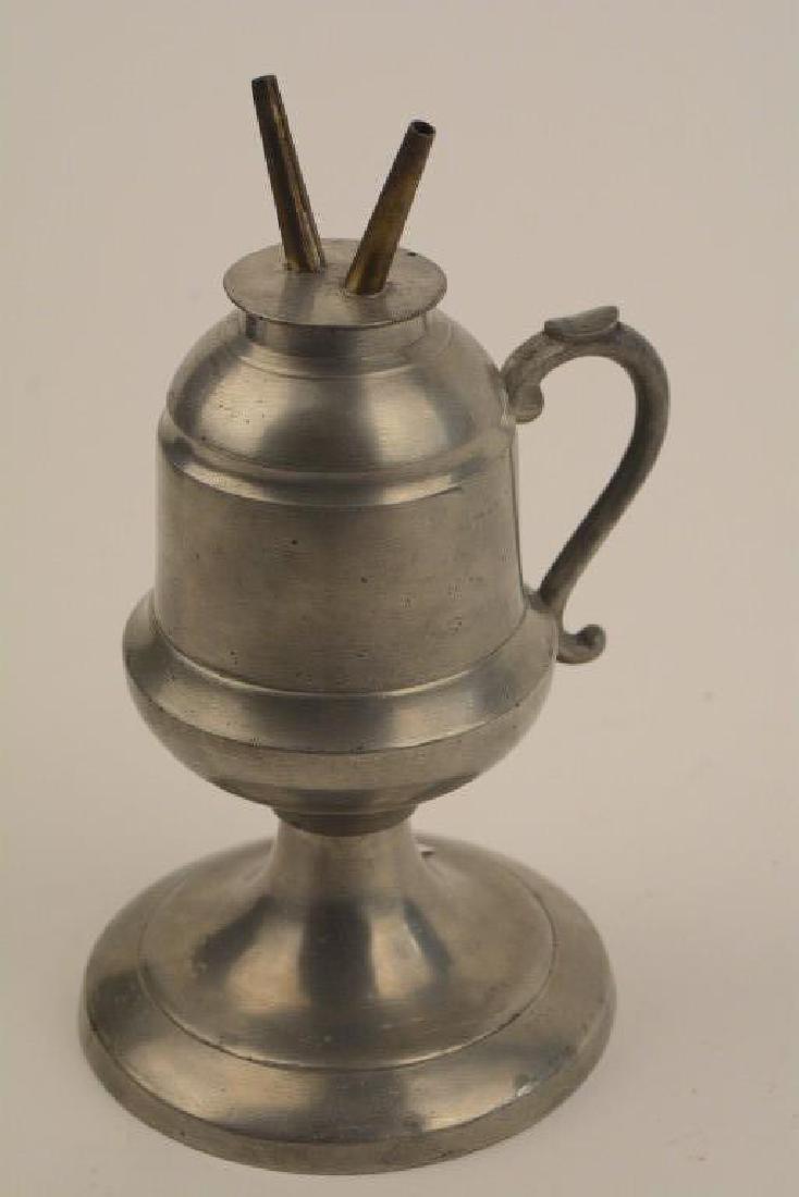 Extraordinary Antique Pewter Whale Oil Lamp: A Remarkable Antique 1800's double burner Whale Oil Lamp. Stands 7-1/2 inches tall on a raised base and in pristine condition, finger holder handle. A wonderful primitive decor piece. (CP-125)