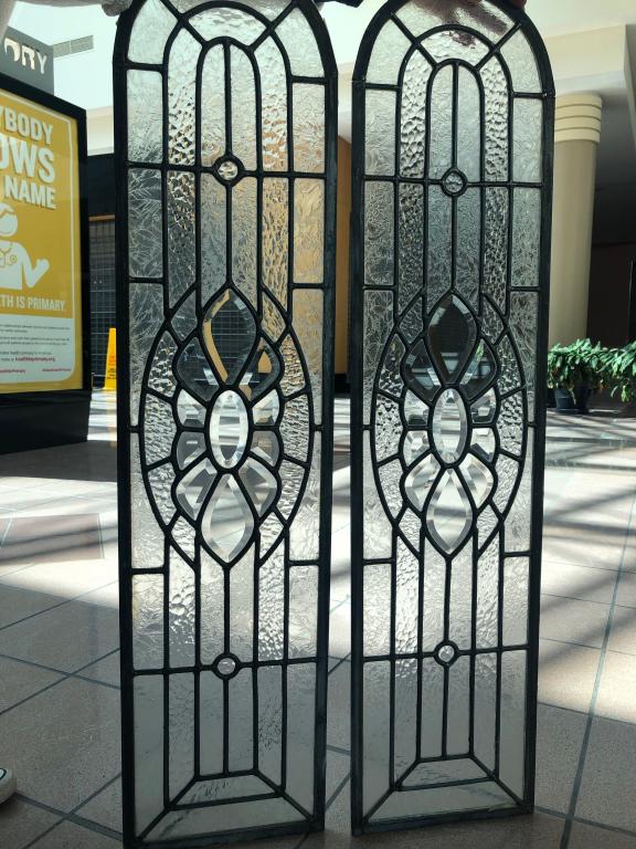 Pair of Rare Arch Topped Leaded Glass Panels: A rare & eye catching identical pair of arched leaded glass panels. Beautiful traditional design featuring textured glass and the light plays wonderfully off of the glass panels. Ideal for the archite