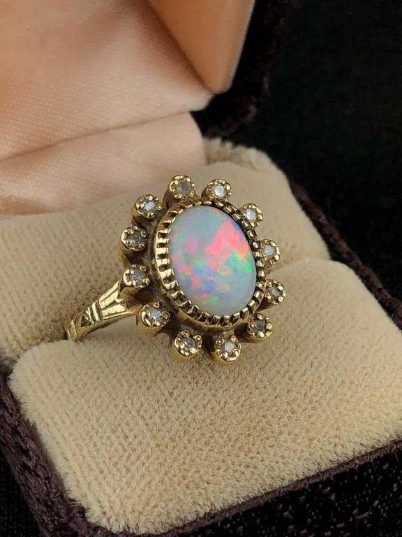 14K Yellow Gold Opal & Diamond Ring: Vintage Estate Ring, 14K yellow gold with Center Opal Approx. 10mm x 8mm and 12 surrounding single cut diamonds, approx. .20 total weight . Approx. size 7 Overall Ring measures: 17mm long x 15mm wide.