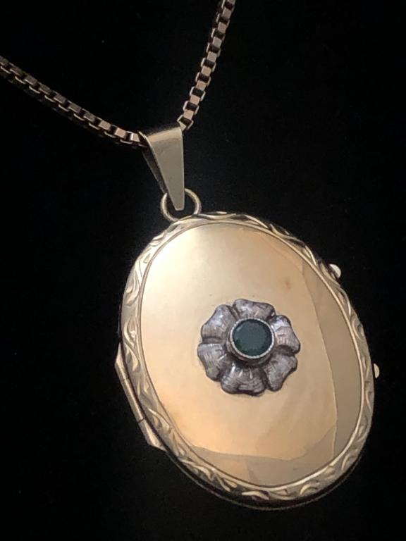 Yellow Gold 14K Oval Locket w/ 8K Y Gold Chain: European Yellow Gold 14K Oval Locket marked "585" with approx. 3mm Emerald Center Stone on an 8K Yellow Gold Chain marked '333". Locket measures: 1-1/2" tall x 1". Chain Measures 20" long. Total weigh