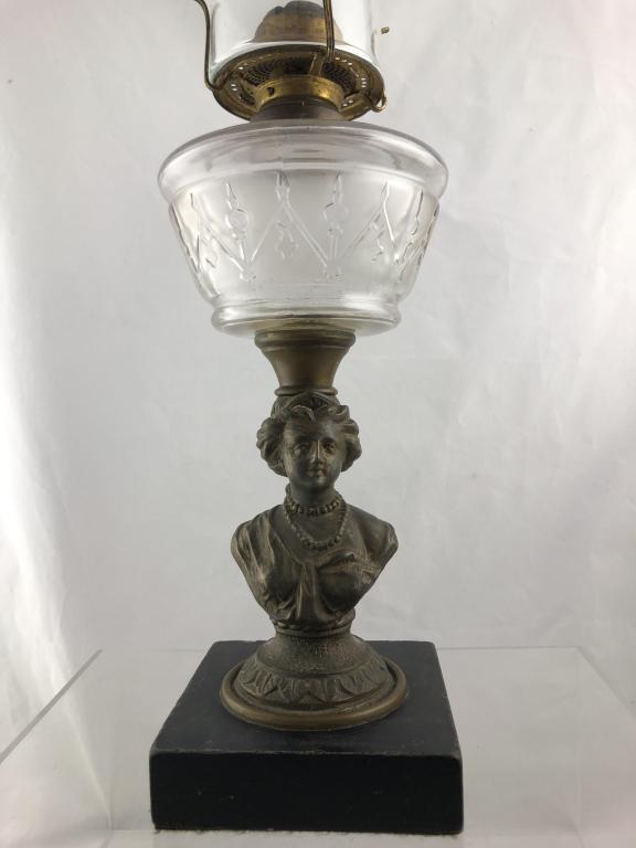 Antique Bronze Figural Table Oil Lamp: Antique oil / kerosene table lamp with decorative pressed glass font and cast bronze body in the shape of figural female bust on square stone base. Comes with Manhattan Brass Company flat wick burner