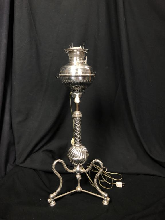 Rare Silver Tripod Adjustable Piano FloorTableLamp: Rare chrome plated extendable tripod piano floor table lamp. Wonderful detail on an unusual find! Needs shade. Converted from Oil to Electric. Perfect next to a chair for right light height! Measures: