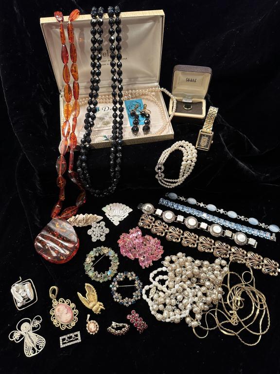 25+pcs. Assorted Vintage Costume Jewelry: Lot of vintage costume jewelry including: 4 rhinestone brooches; 2 cameo pendants; 1 Gruen quartz watch; 1 Swank Onyx tie clip; 1 amber necklace; 2 gold colored chains; 3 pearl necklaces; 1 three stra