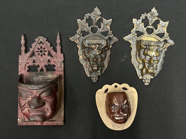 4 Antique FaceCast Match Safe Holder Wall Pockets: 4 Antique wall hanging match safes / holder / wall pockets including: 1 & 2) pair of cast metal horned Pan figure devil safes, measures: 6" h; 3) red enameled gothic round face / theatrical mask match