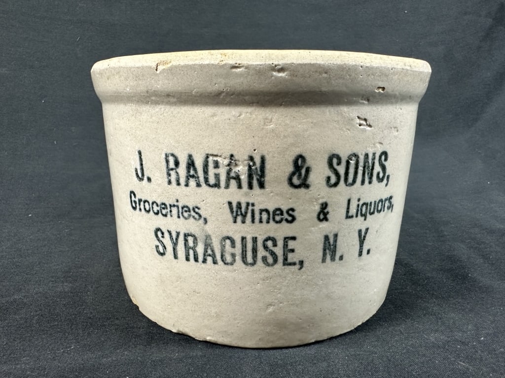J Ragan & Sons Grocer Syracuse Stoneware Crock: J Ragan & Sons Grocer Syracuse Stoneware Crock Half gallon stoneware crock with dark glaze interior and three stenciled lines reading "J.Ragan & Sons, Groceries, Wines & Liquors, Syracuse, N.Y.". Meas
