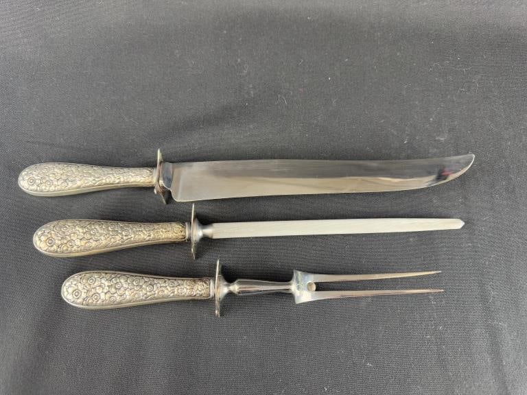 3Pcs. Sterling Handle Sheffield Carving Set: Set of three Sterling Silver handled carving set with stainless steel blades. Includes: 13-5/8" knife; 12-1/4" sharpening rod; 10-1/4" carving fork. Total Weight: 15.415 Troy Oz.