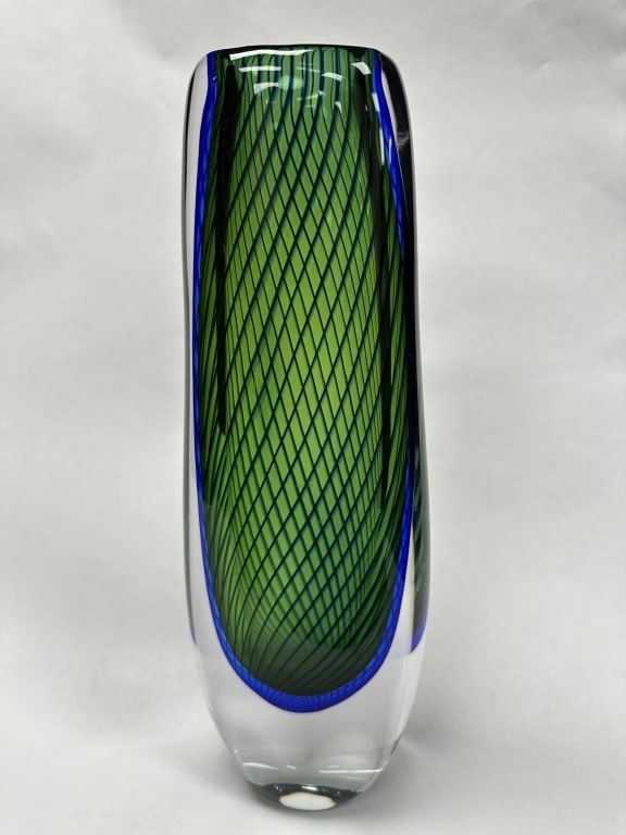 Stunning Kosta Swedish Handblown Art Glass Vase: A superb example of Kosta Swedish handblown art glass, this sculptural vase showcases a vibrant emerald green lattice (filigrana) interior, masterfully encased within a thick, clear crystal casing. Th
