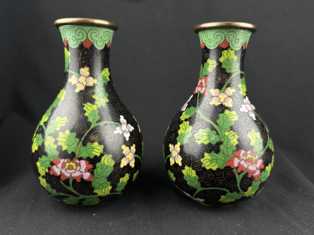 Pr. Chinese Petite Black Cloisonne Vases w/Florals: Pair of petite Chinese cloisonne vases with pink flowers and green foliage on a black field. Jade colored decorative borders brass rim and foot. Marked "China" on base. Measures: 6-1/4" H x 4" W.