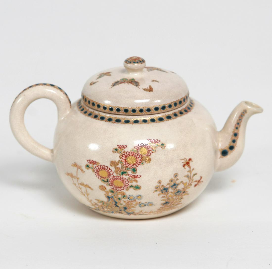Imperial Satsuma Teapot, Meiji Period (1868-1911): Imperial Satsuma Teapot, Meiji Period (1868-1911). Rrae gossu blue with floral and butterfly motif. Red signature and rare blue satsuma crest of Lord Shimazu. Dimension: 3 1/2" high x 5 3/4" wide A LI
