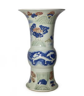 Large Porcelain Gu Vase, Dragons & Landscape: DescriptionLARGE PORCELAIN GU VASE, DRAGONS & LANDSCAPE.Date: 19th CenturyLarge molded and incised gu-form vase with underglaze red and blue designs of landscapes and dragon on a light celadon field.