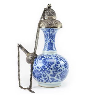 Chinese Blue & White Porcelain KENDI With Silver Mounts: DescriptionCHINESE BLUE & WHITE PORCELAIN KENDI WITH SILVER MOUNTS.Date: Kangxi Period, 17th to 18th CenturyA Kangxi period blue and white porcelain floral design. With fine matching repoussé silver