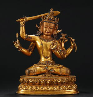 A Sino-Tibetan Bronze-Gilt Manjusri: A Sino-Tibetan Bronze-Gilt Manjusri The figure is intricately modelled seated in dhyanasana on a double-lotus base with four arms. The upper right hand is welding a sword above his head, and the lower