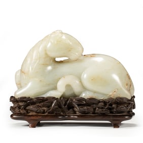 A WELL-CARVED WHITE JADE FIGURE OF A RECUMBENT HORSE