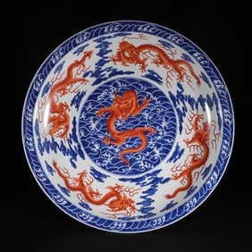 A CHINESE UNDERGLAZE BLUE AND IRON RED DRAGONS PLATE