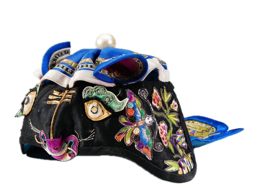 AN EMBROIDERED TIGER HAT: AN EMBROIDERED TIGER HAT Of rounded shape, the black silk embroidery the hat in tiger head. Dimension: L. 26 cm. W. 14 cm.