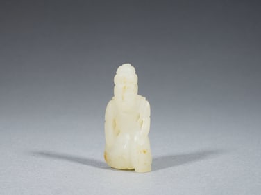 A CARVED WHITE JADE DEITY