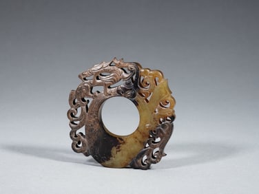 A FINE CARVED AND RETICULATED JADE ARCHER RING SHE