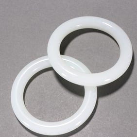 A PAIR OF CARVED WHITE JADE BANGLES
