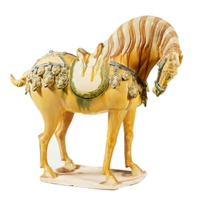 A SANCAI GLAZA POTTERY CAPARISONED HORSE
