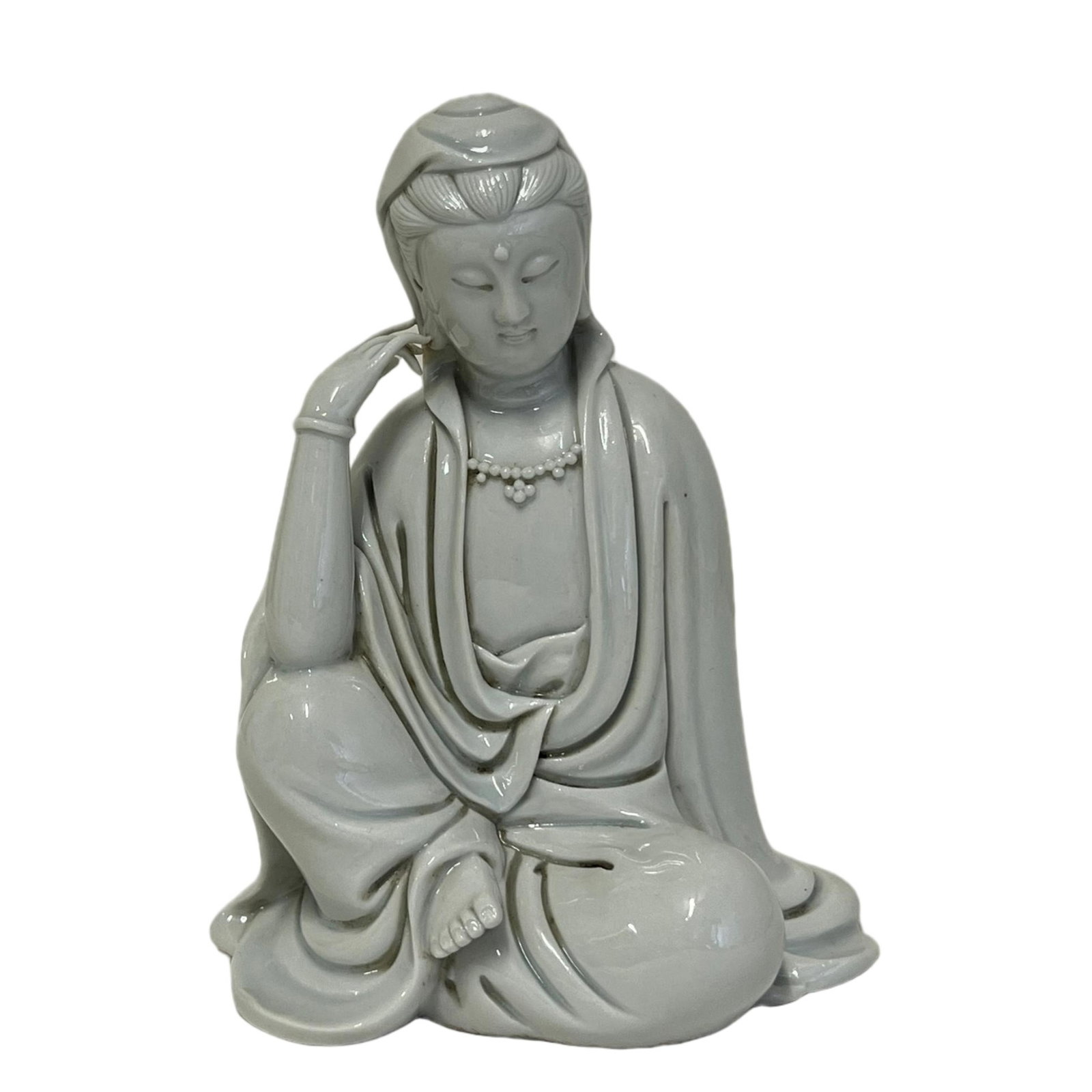 A CLAIR-DE-LUNE SEATED GUANYIN: A CLAIR-DE-LUNE SEATED GUANYIN His hair is swept back into a topknot beneath the veil, and long plaits cascade down the shoulders. The face has downcast eyes and a serene expression. The deity wears b