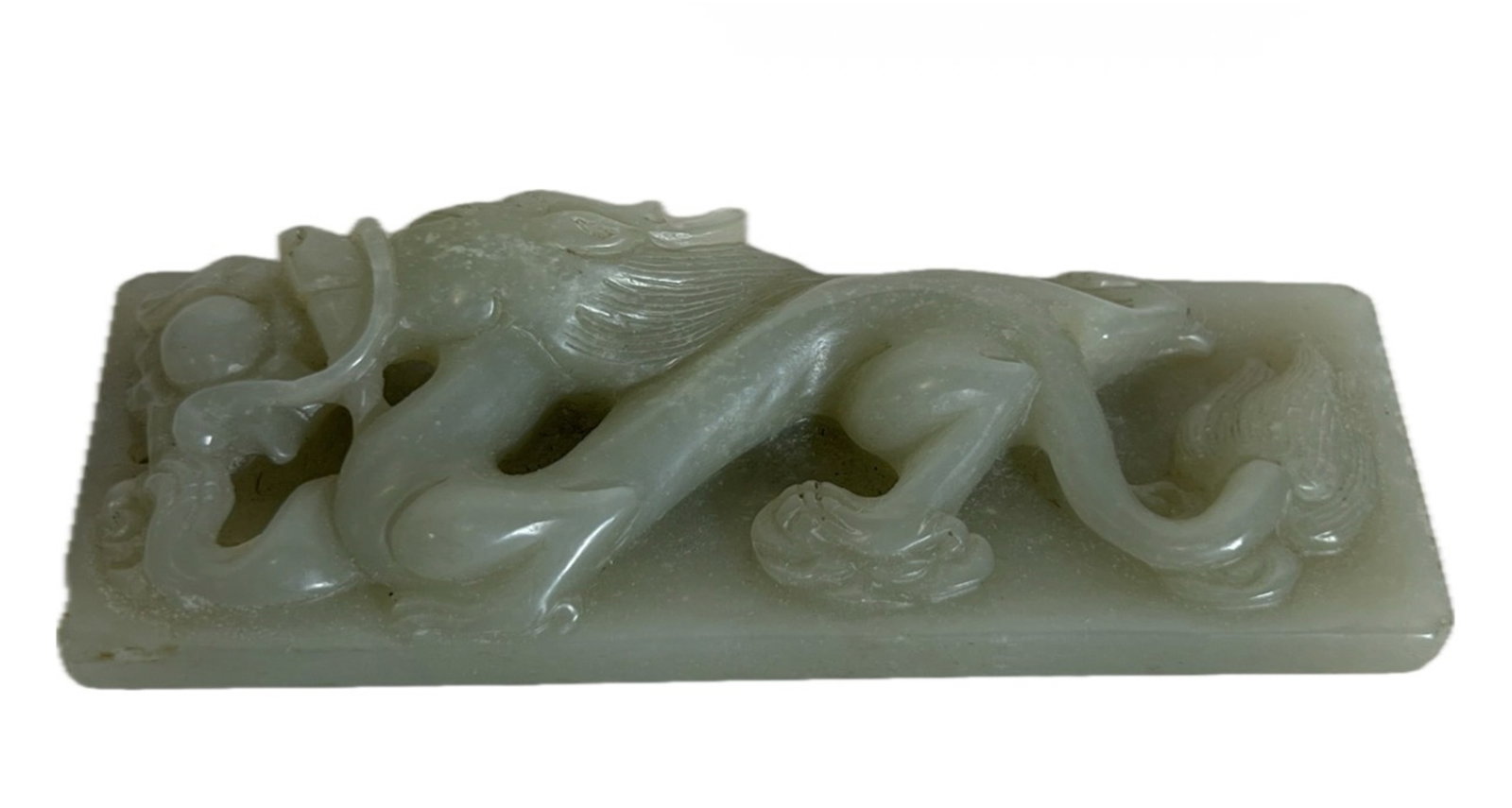 A CARVED JADE DRAGON PAPER WEIGHT: A CARVED JADE DRAGON PAPER WEIGHT Surmounted with dragon chasing flaming pearl. DIMENSION: L. 8.5 cm. W. 3 cm. A LIST OF RECOMMENDED THIRD-PARTY SHIPPER IS AVAILABLE UNDER SHIPPING INFORMATION.