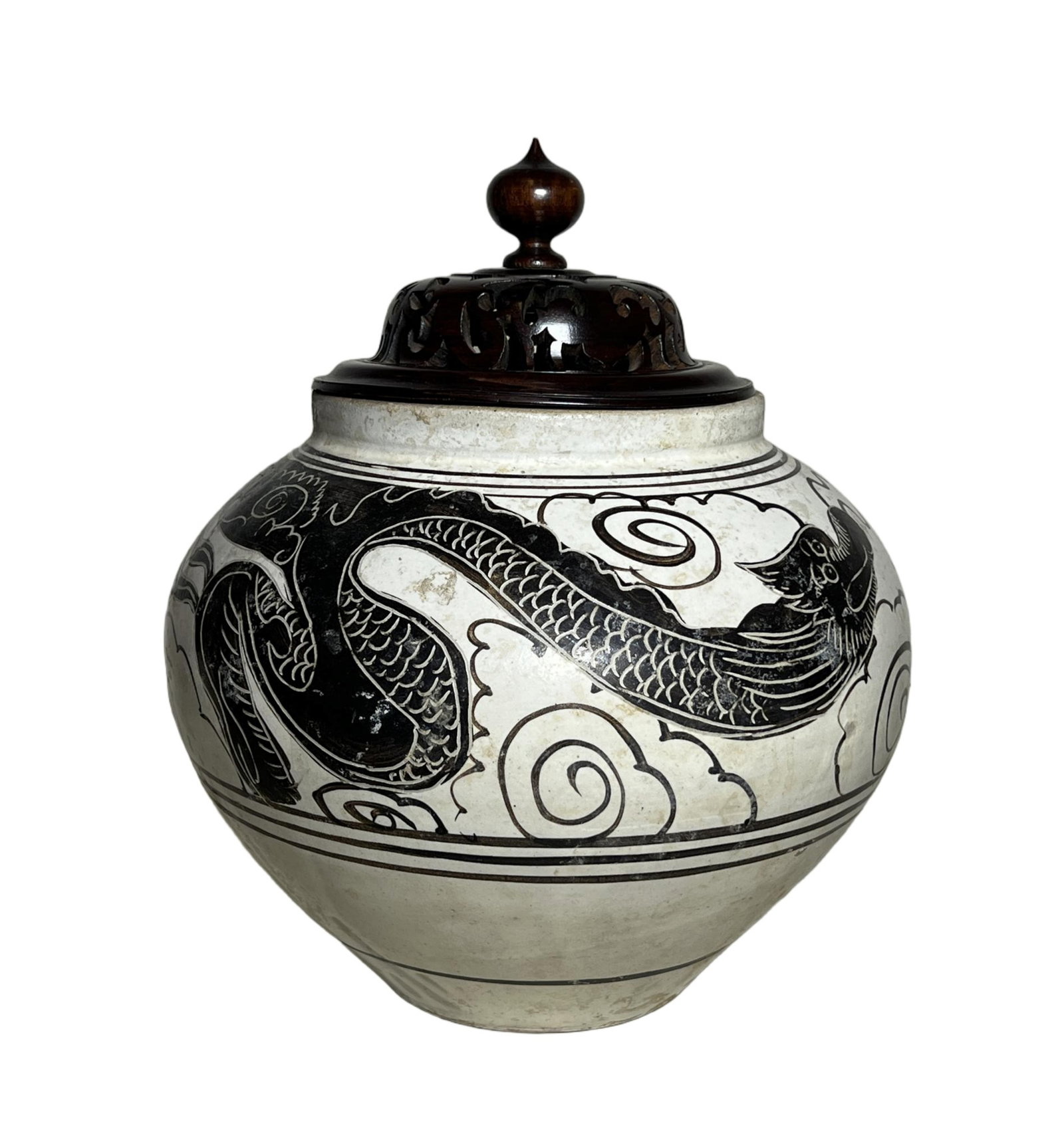 A CIZHOU GLAZE POTTERY DRAGON JAR: A CIZHOU GLAZE POTTERY DRAGON JAR Of baluster shape, incised with flying dragon among clouds, surmounted with dome cover ended with bud finial. DIMENSION: H. 30 cm. A LIST OF RECOMMENDED THIRD-PARTY